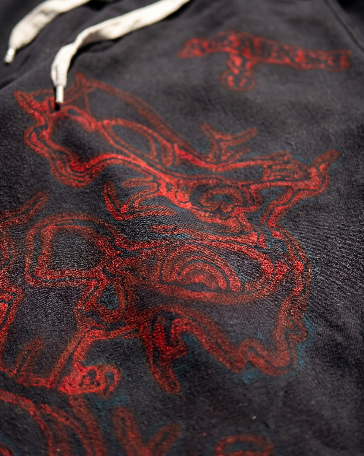 ATO BLACK AIRBRUSH SWEAT JORTS – close-up of the red airbrushed skull and drawstring waistband