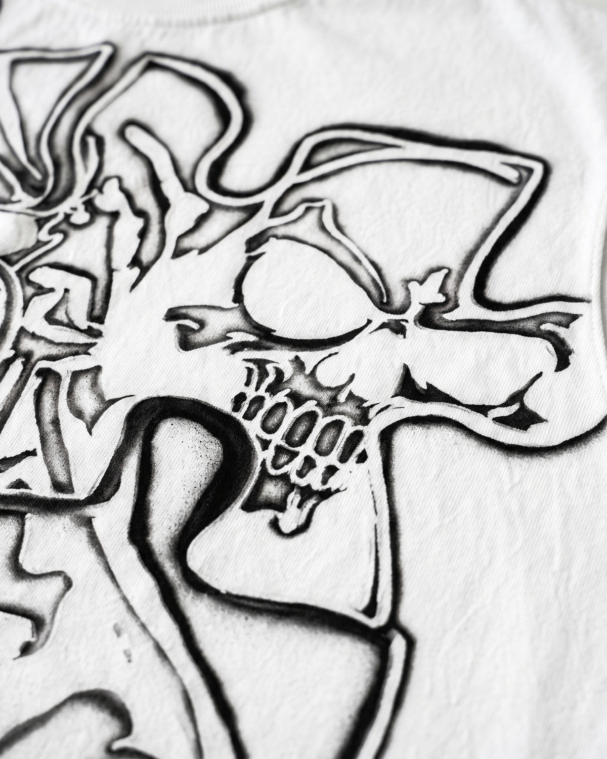 ATO AIRBRUSH Skeleton Cutoff TEE – close-up of an airbrushed skull in the puzzle graphic